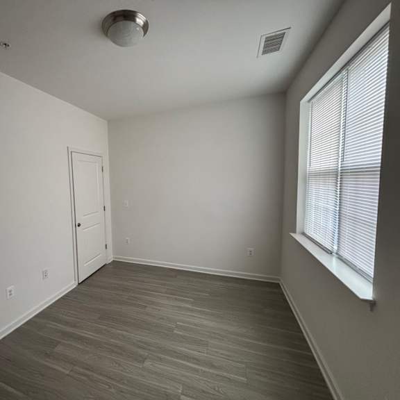 a room with a door and a window with blinds.