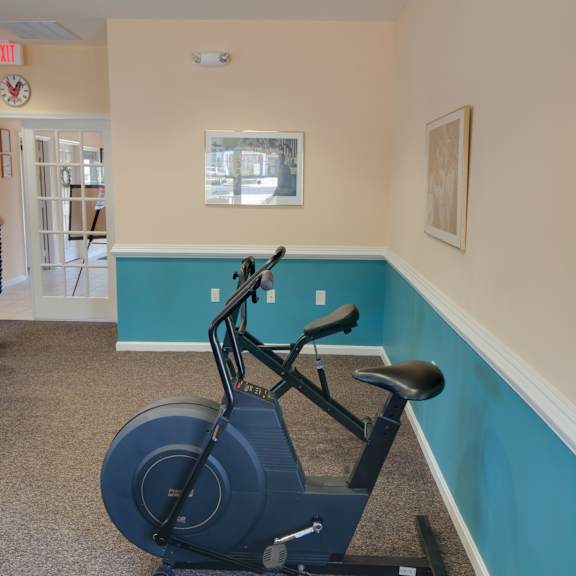 a stationary bike is in a corner of a room with a blue wall.