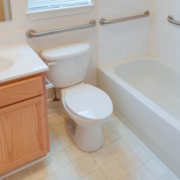 a white toilet sits next to a white bathtub in a bathroom.