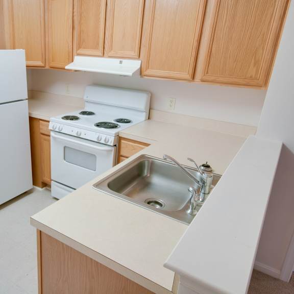 a white refrigerator is in a kitchen with wooden cabinets.