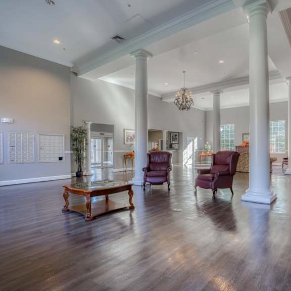 a large living room with pillars and a fireplace