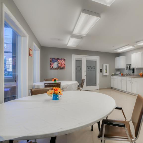 a dining room with a white table and chairs and a kitchen