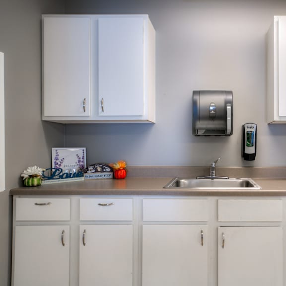 a kitchen with white cabinets and a sink and a counter