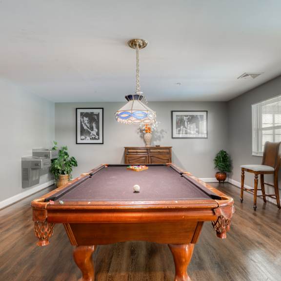 a pool table in a living room with a chandelier
