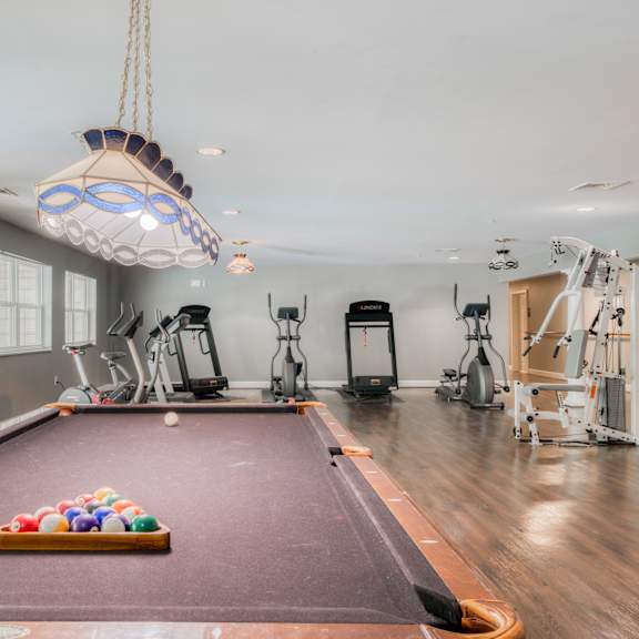 a gym with a pool table and exercise equipment