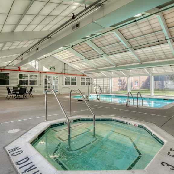 a hot tub in a building with a pool and