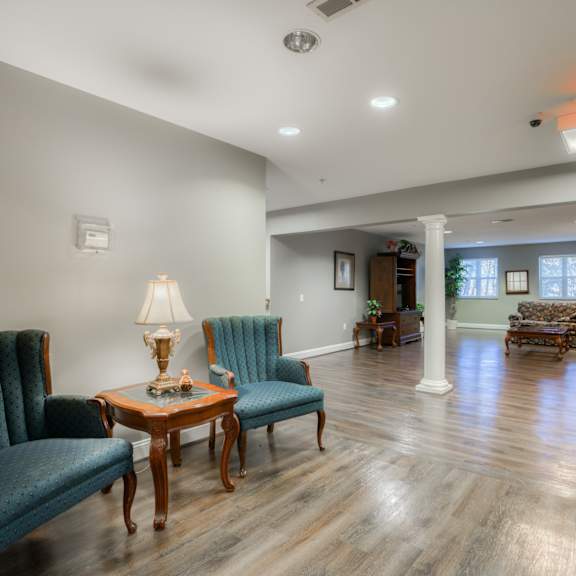 a large living room with blue chairs and a wooden floor