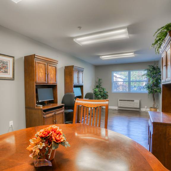 the dining room and living room of a home with a wooden table and chairs
