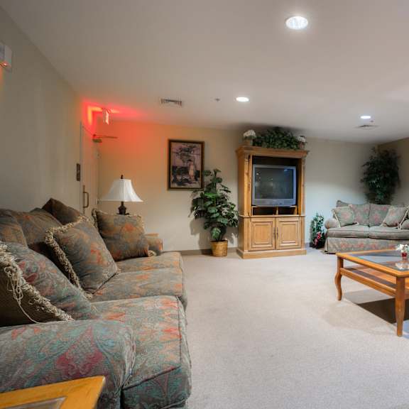 a living room with couches and a table and a television