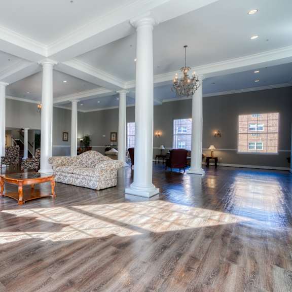 a large living room with pillars and a fireplace