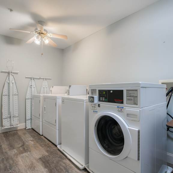 a laundry room with washes and dryers and a ceiling fan