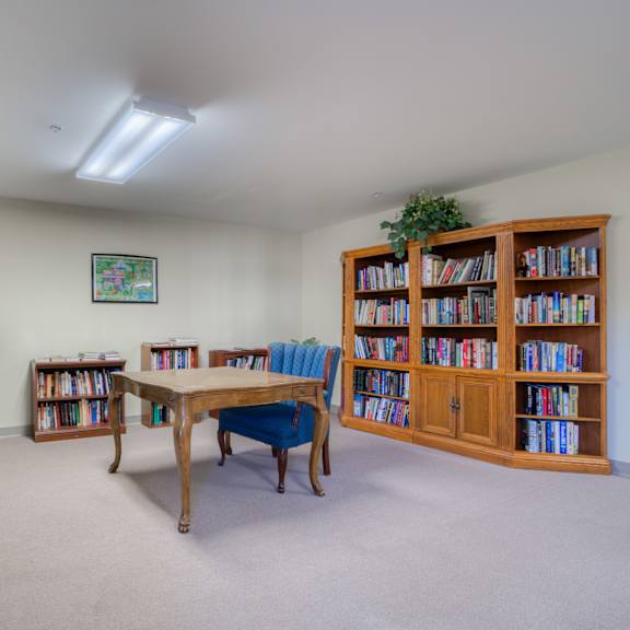 a library with a table and chairs and shelves of books