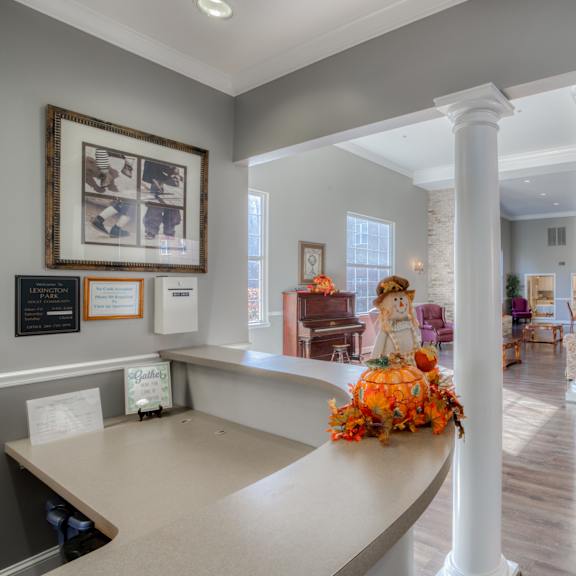 a large lobby with columns and a counter with flowers on it