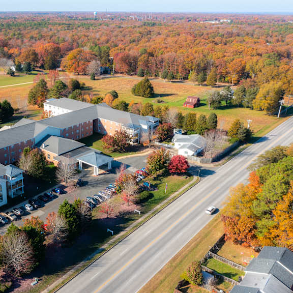 a view from above of a building with a parking lot and a tree