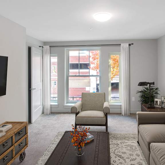 a living room with a couch and a chair and a television