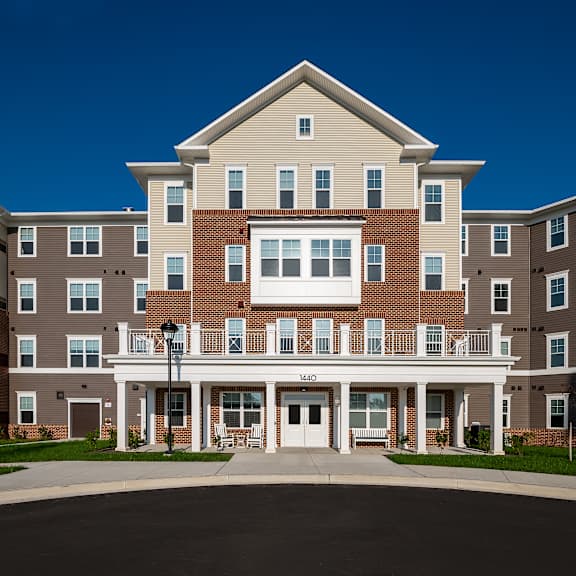 a large apartment building with a balcony and a driveway