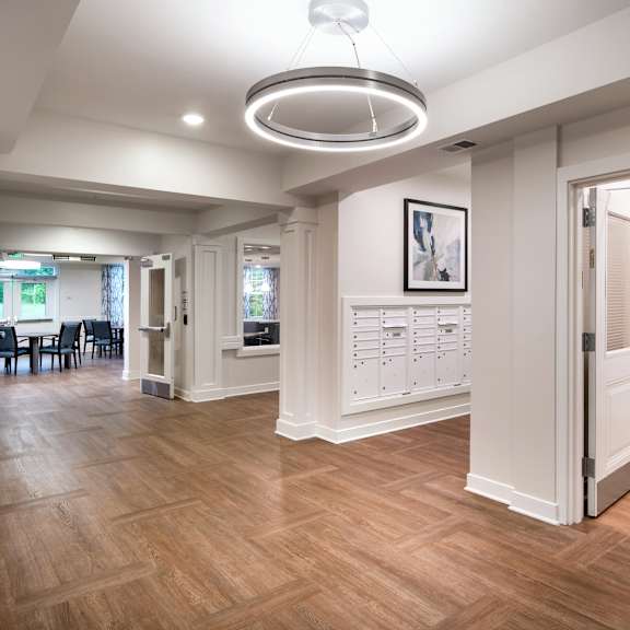 a renovated living room and dining room with wood flooring and white walls