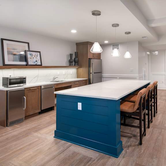 a kitchen with a blue island and a dining room with chairs