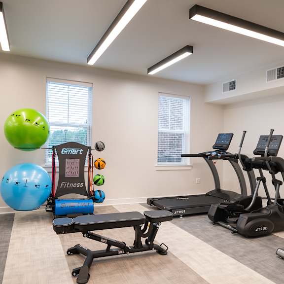 a gym with cardio equipment and weights at the preserve apartments
