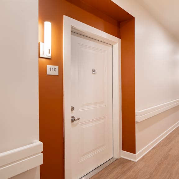 a corridor with a white door and a hallway with orange walls