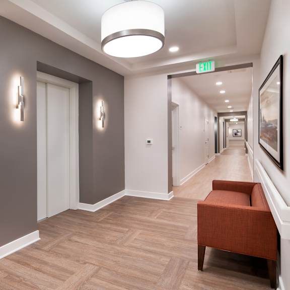 a hallway with a couch and a chair and a corridor with doors