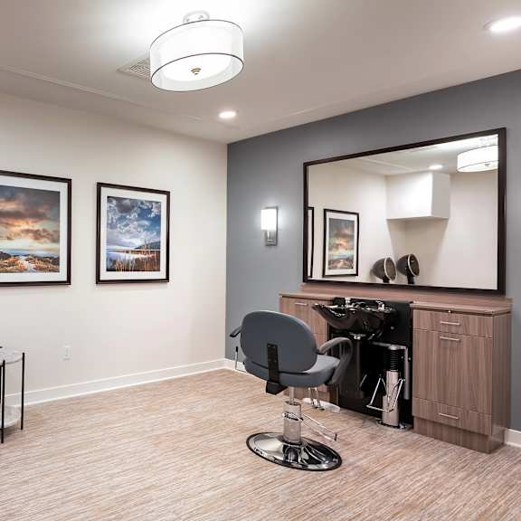 a salon room with two chairs and a mirror