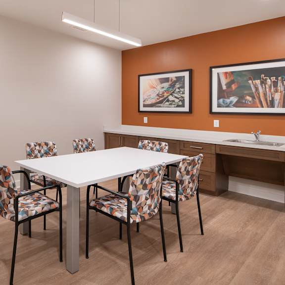 a dining area with a table and chairs and a sink