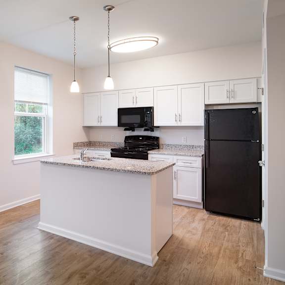a kitchen with an island and a black refrigerator