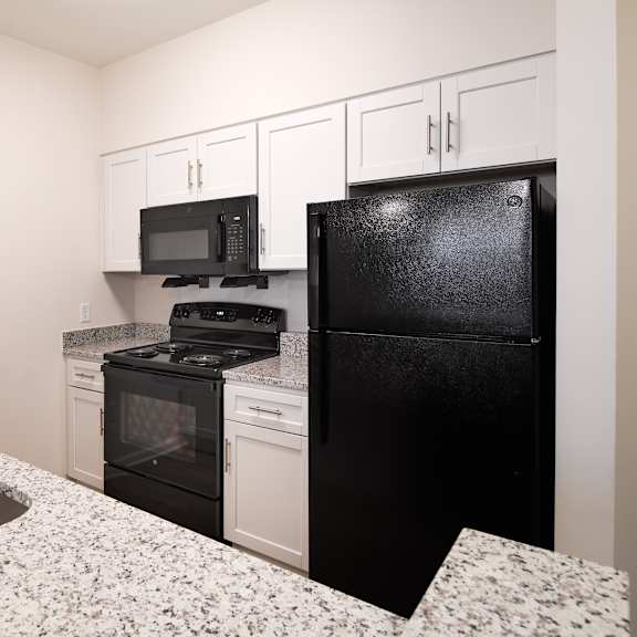 a kitchen with granite counter tops and black appliances