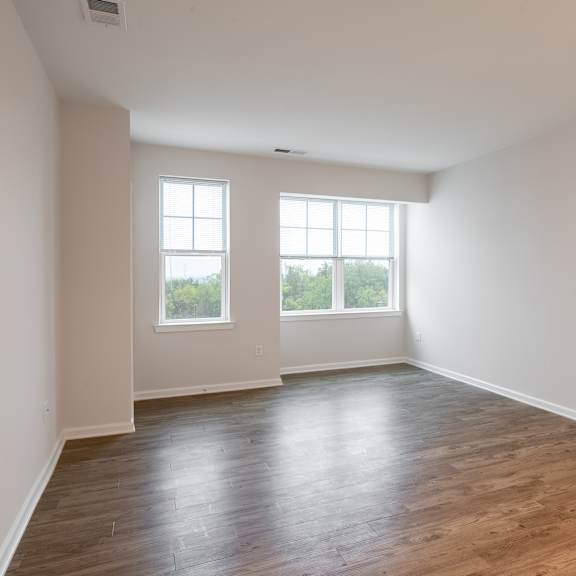 an empty living room with white walls and wood floors
