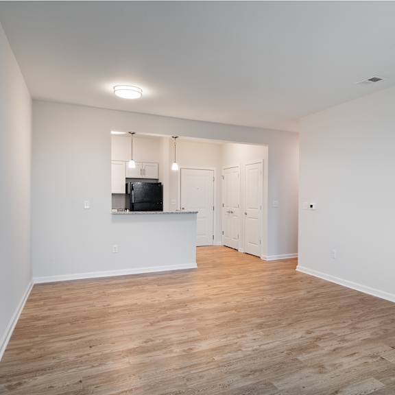 an empty living room with white walls and wood flooring