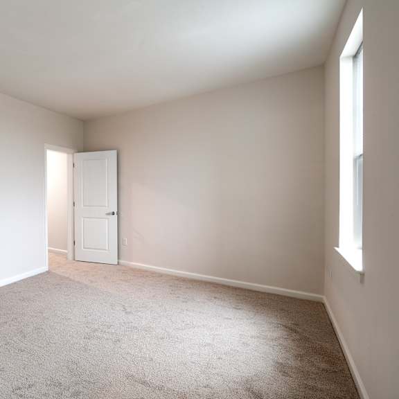 an empty living room with white walls and a white door