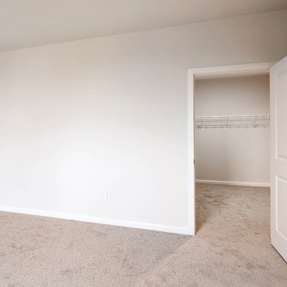 an empty room with white walls and a closet