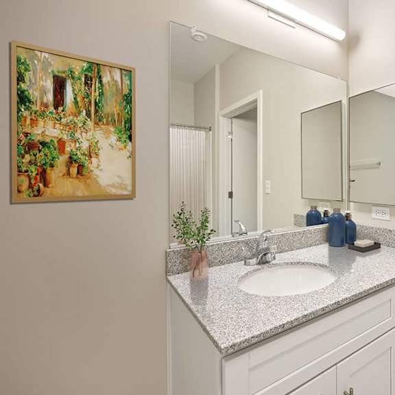 a bathroom with a sink, mirror, and a painting on the wall.