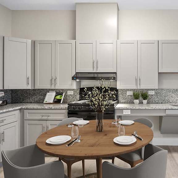 a modern kitchen with a dining table set for two.