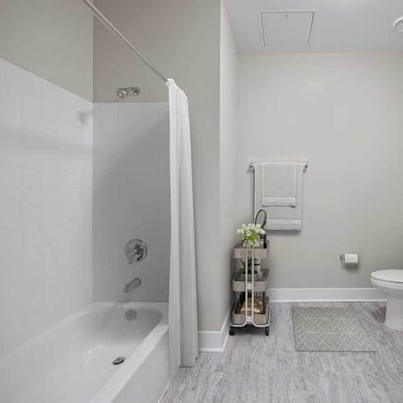 a bathroom with a white tub, toilet, and sink.