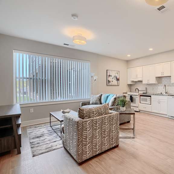 a living room with a couch and a chair and a kitchen