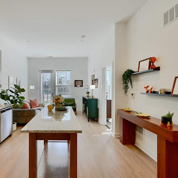 now leasing senior 1-bedrooms in baltimore, md. a kitchen with wooden cabinets and a table in the middle.