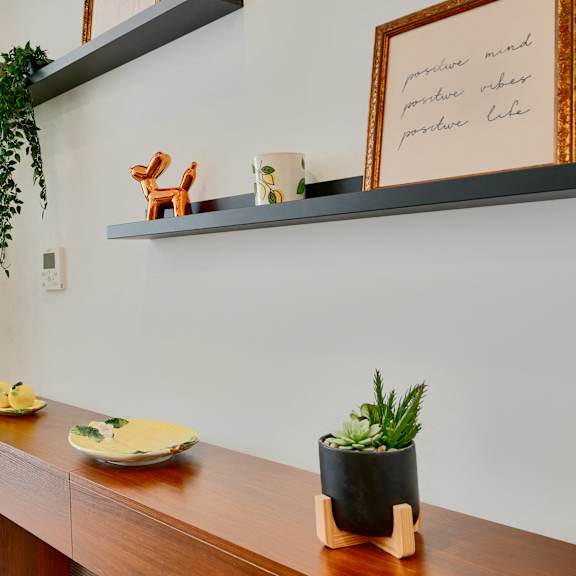now leasing senior 1-bedrooms in baltimore, md. a wooden table with a plant and a framed picture on it.