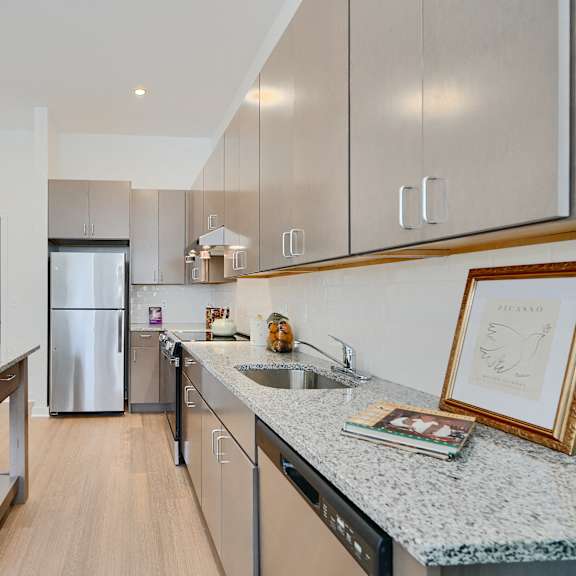 now leasing senior 1-bedrooms in baltimore, md. a kitchen with a granite countertop and stainless steel appliances.