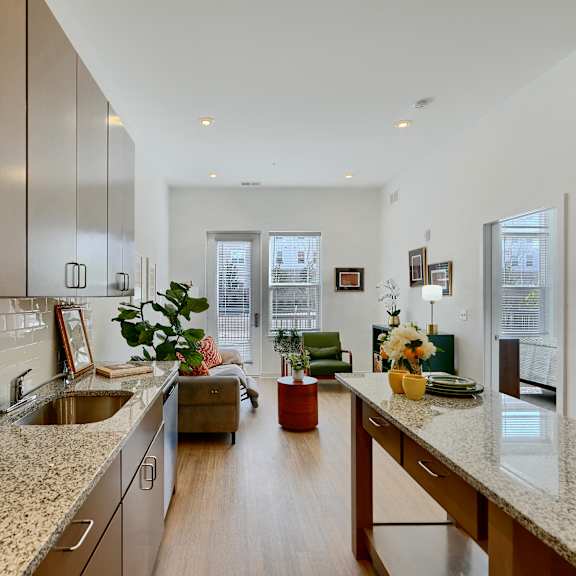 now leasing senior 1-bedrooms in baltimore, md. a kitchen with a granite countertop and wooden cabinets.