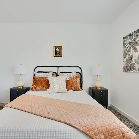 now leasing senior 1-bedrooms in baltimore, md. a bedroom with a large bed and a chair.