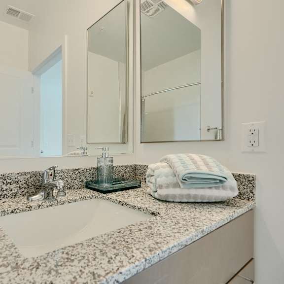 now leasing senior 1-bedrooms in baltimore, md. a bathroom with a marble countertop and a large mirror.