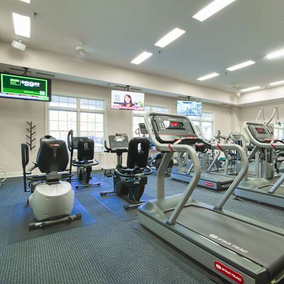 a gym with various cardio machines and other workout equipment