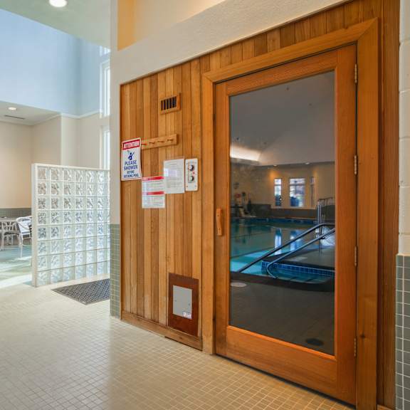 a wooden door in a lobby of a building with a pool
