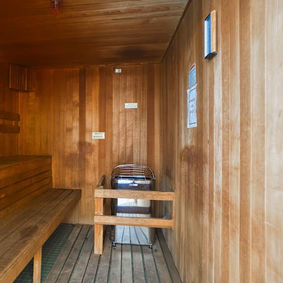 a wooden sauna with a bench and a table
