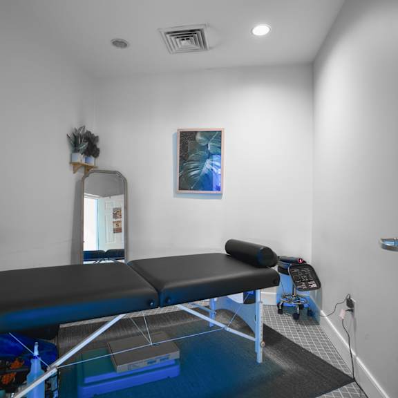 a treatment room with two massage tables and a mirror