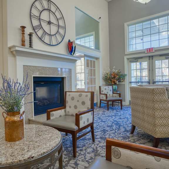 a living room with a fireplace and a clock on the wall