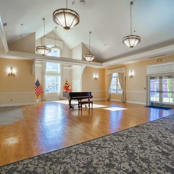 an empty living room with a grand piano and a rug