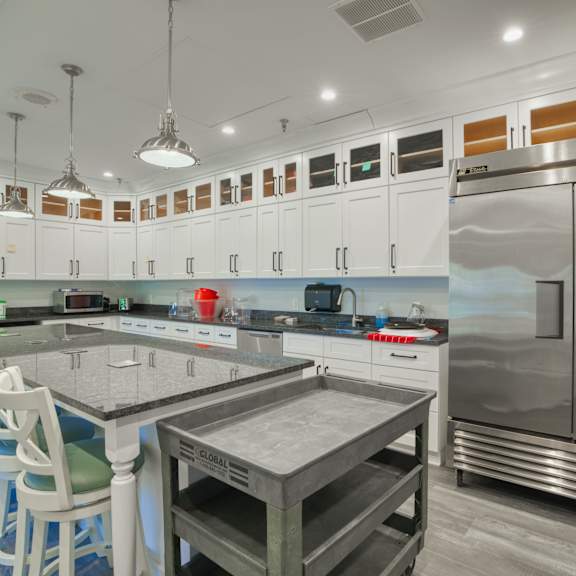 the kitchen has a large island and stainless steel appliances